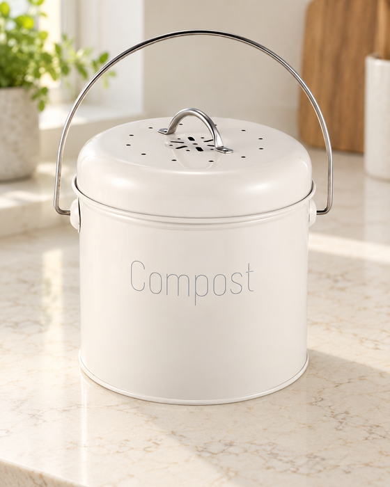 Cream-white compost container with metal handles on a kitchen counter.