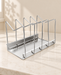 Silver pot and pan organizer rack on an ivory kitchen counter.