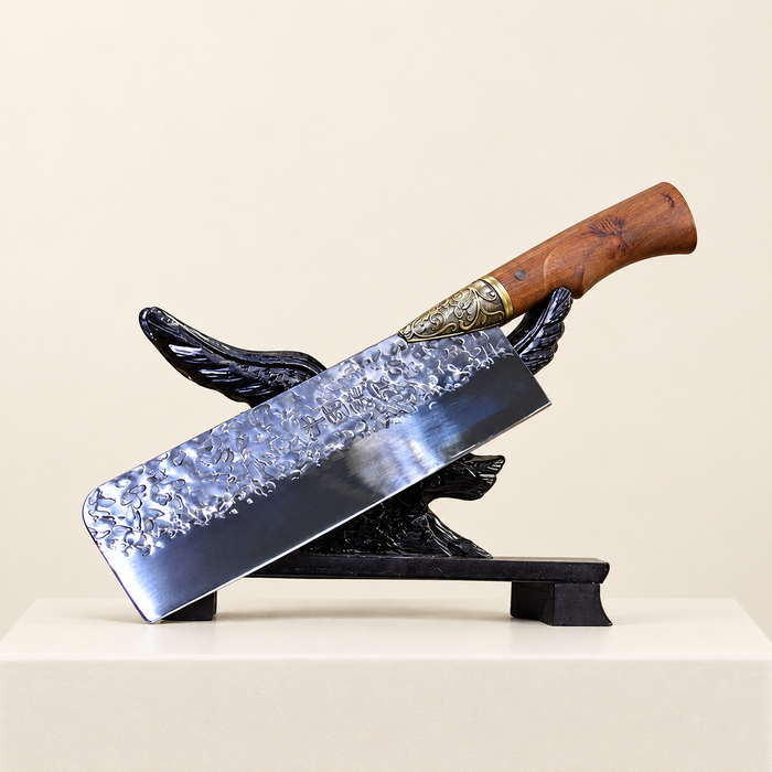 Kitchen knife with a wooden handle and patterned blade resting on a dark display stand