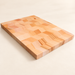 Rectangular wooden cutting board on an ivory surface.