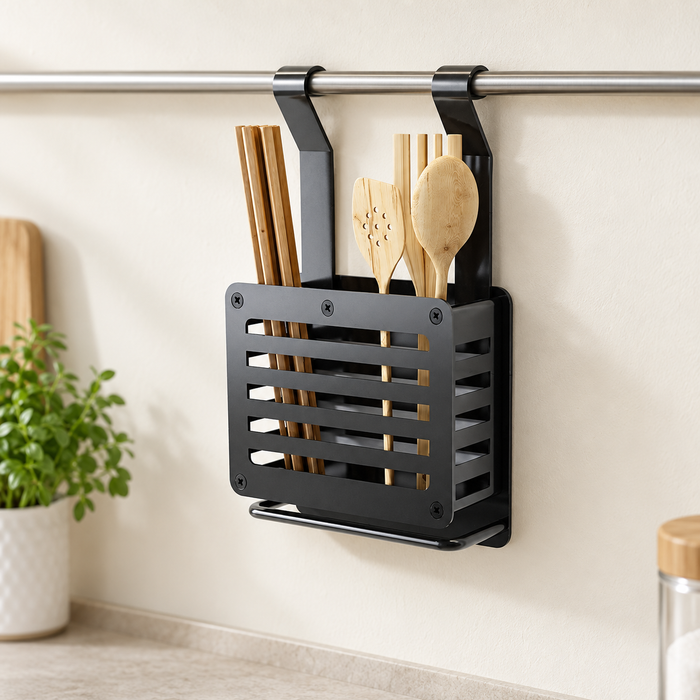 Dark hanging utensil rack holding wooden kitchen utensils against an ivory wall.