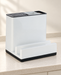 Empty white and black kitchen organizer on an ivory counter.
