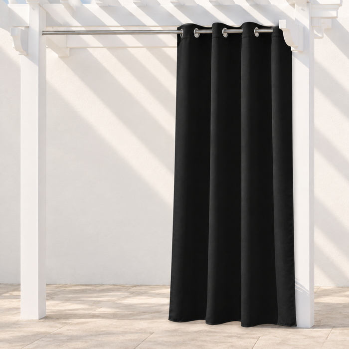 Black curtain panel hanging from a silver rod in an ivory alcove.