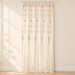 Cream macrame curtain against an ivory wall