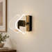 Triangular illuminated wall lamp with a gold-toned mount on a warm neutral wall.