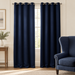 Navy eyelet curtains in an ivory room with a matching armchair.