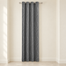 Grey grommet curtain panel with white wavy dotted lines in an ivory alcove.