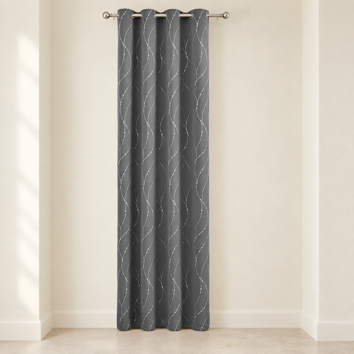 Grey grommet curtain panel with white wavy dotted lines in an ivory alcove.