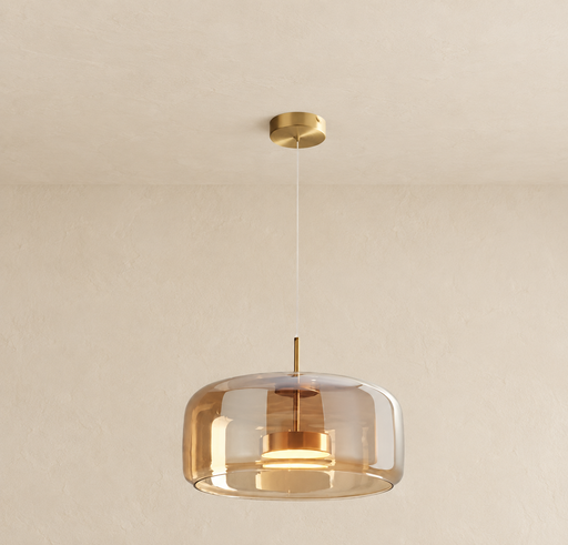 Amber glass pendant light with a gold canopy and stem, suspended against an ivory interior.