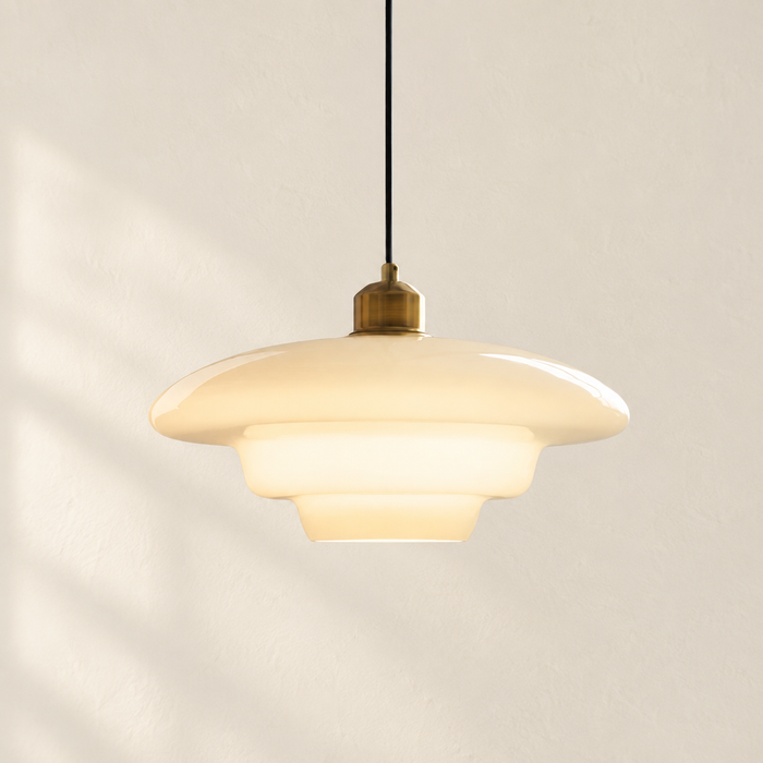 Ivory glass pendant light with stepped shade and brass cap.