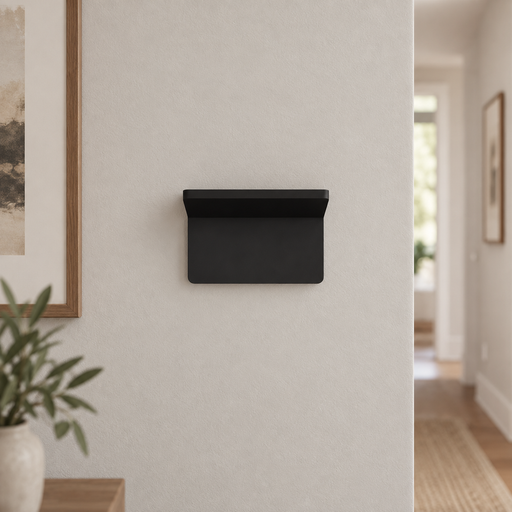 Compact matte black wall light mounted on a pale hallway wall.