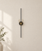 Black vertical wall light with a gold deer motif on an ivory wall.