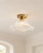 Brass and fluted glass ceiling lamp in an ivory entryway.