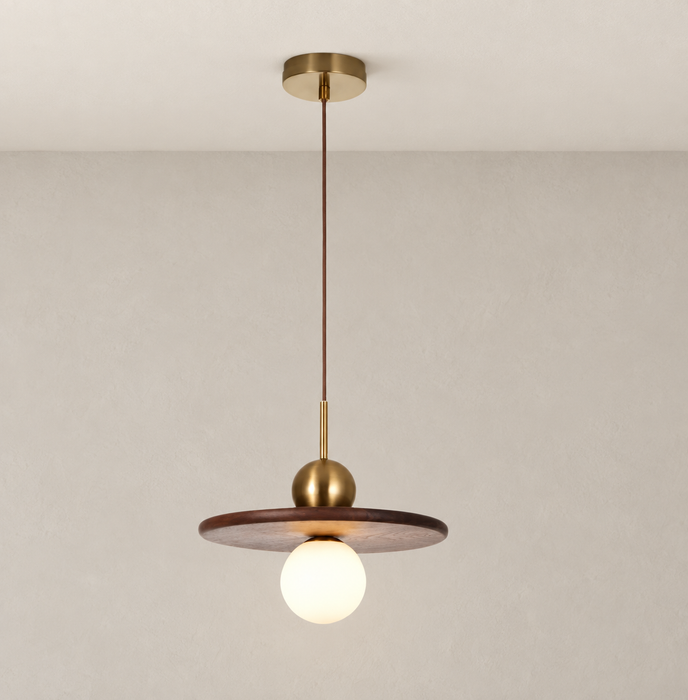 Walnut disc pendant with gold fittings and a glowing globe