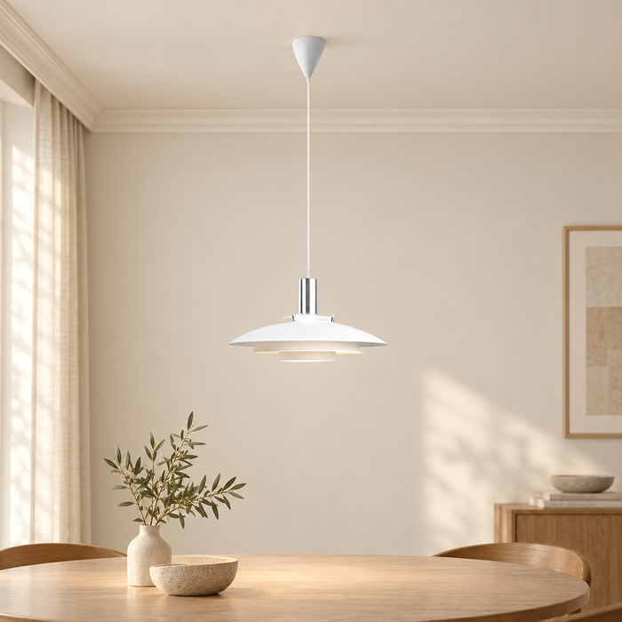 White layered pendant lamp mounted above a table in an ivory interior.