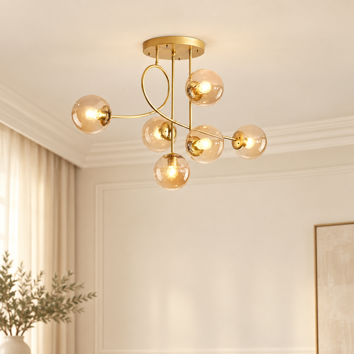 Gold geometric chandelier with six amber glass globes in an ivory room.