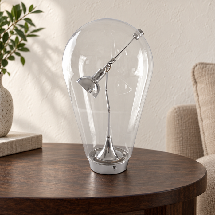 Clear glass art lamp on a dark wood side table.