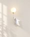 White bear-shaped wall lamp holding a glowing globe against ivory plaster.