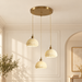 Three ceramic pendant shades with gold cables mounted in an ivory interior.