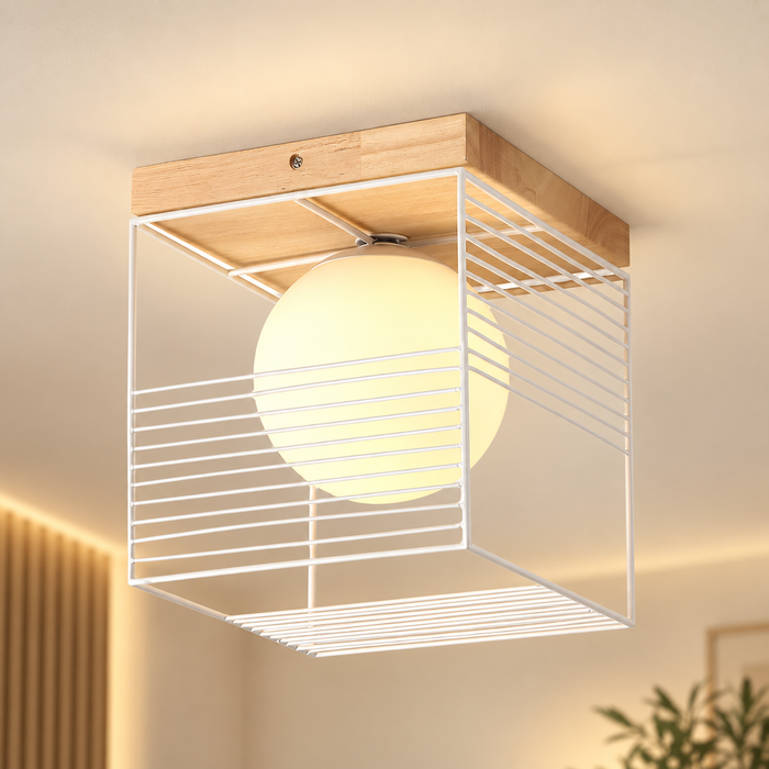 White wire-cube ceiling light with wooden plate and glowing glass globe.