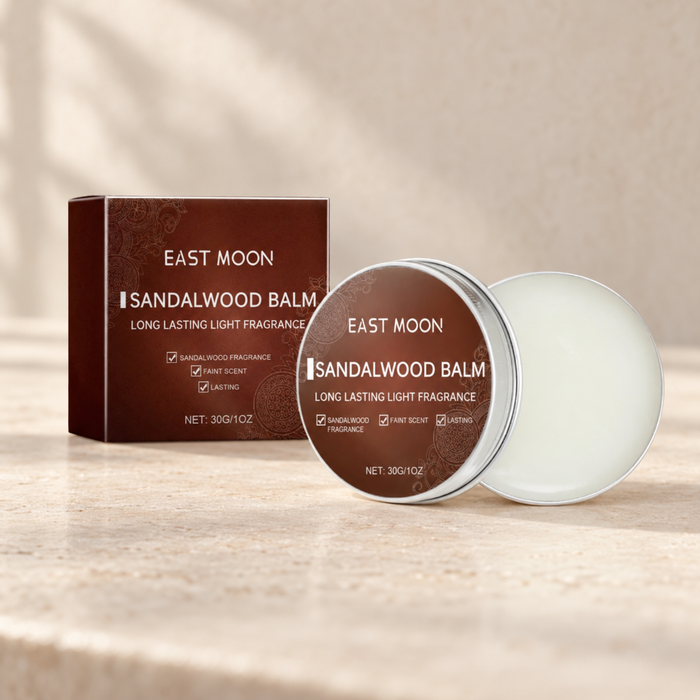 Sandalwood solid balm with its original brown packaging on a warm stone vanity.