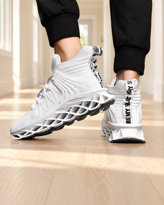 White knit sneakers with open lattice soles worn with black trousers in a bright hallway.
