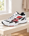 White, black and red mesh sneaker on a pale wooden bench beside a window.