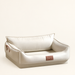 Ivory rectangular pet bed with raised sides and a back cushion on a neutral ivory background.