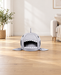 Grey shark-shaped pet cave bed with white teeth and side fins in a softly lit living room.