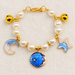 Pearl pet collar with gold bells and blue celestial charms on ivory linen.