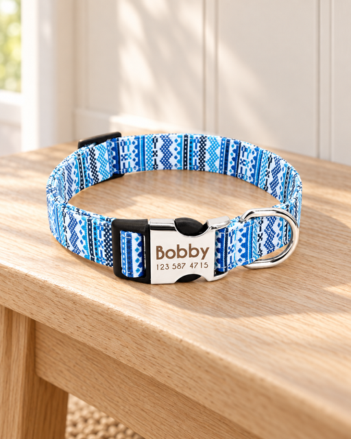 Blue and white patterned dog collar with a silver engraved clasp on a light wooden bench.