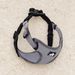 Grey and black dog harness on an ivory floor.