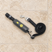 Black handheld dog leash with a coiled reflective strap and silver clasp on an ivory floor.