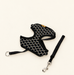 Black diamond-pattern pet harness with matching strap and metal clasp on an ivory surface