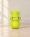 Lime-green rubber monkey dog toy on an ivory stone floor.