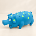 Blue pig dog toy with lime spots on ivory surface