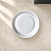 White ceramic pet bowl on an ivory stone floor.