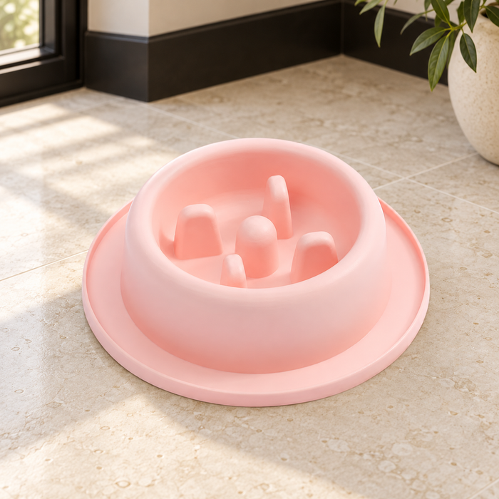 Pink slow-feeder pet bowl with five raised obstacles on an ivory stone floor.