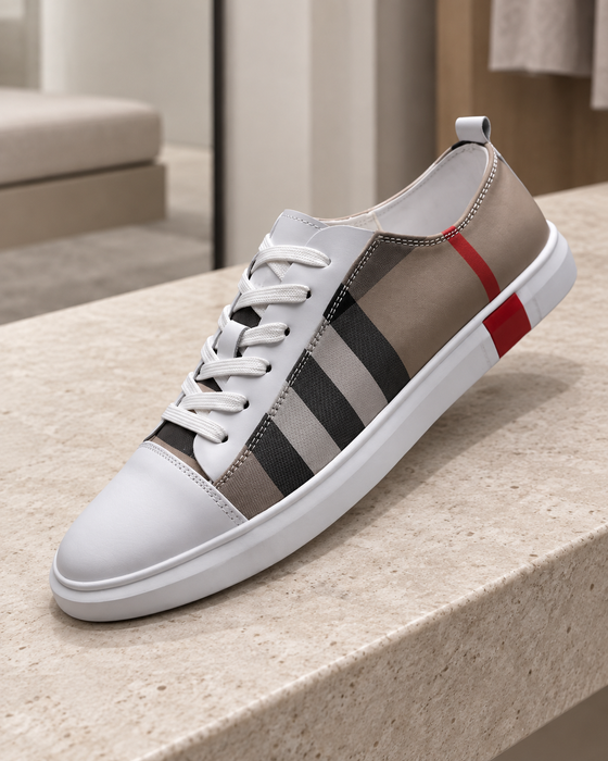White and taupe low-top sneaker with a checked side panel and red heel accent on a pale stone bench.
