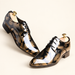 Pair of glossy black and gold floral dress shoes with wooden shoe trees