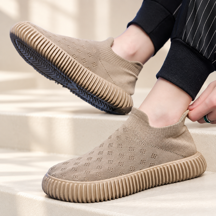 Beige knitted slip-on shoes with deeply ribbed soles on ivory steps