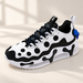 White and black athletic shoe with circular mesh details and blue accents