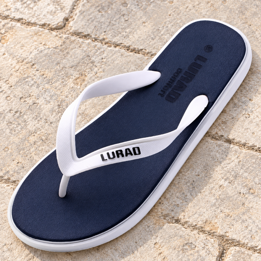 Navy flip-flop with white straps and white sole edge on pale stone patio paving.