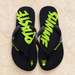 Black and lime flip-flops with graphic footbeds on ivory stone.