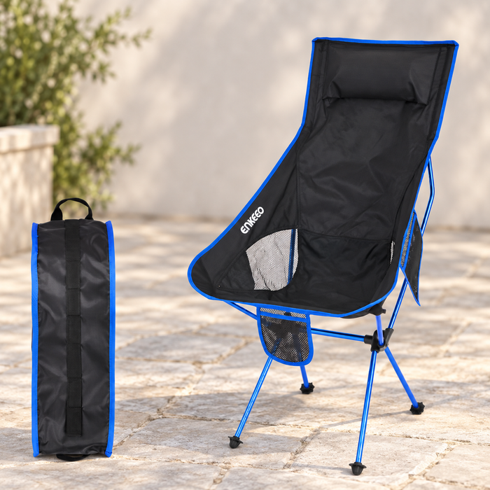 Black and blue camping chair with carrying bag on a pale stone terrace.