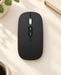 Black wireless mouse with silver scroll wheel on an ivory desk.
