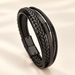 Black multi-strand leather bracelet on ivory surface