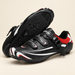 Black red and white cycling shoes with exposed sole on ivory stone