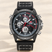 Black multifunction watch with white stitching displayed on an ivory surface.