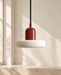 Burgundy and ivory pendant lamp in a softly lit ivory interior.